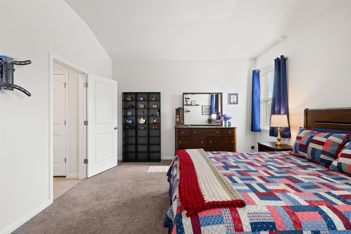 11701 Pecangate Way Manor, TX 78653 - Photo 18 of 40 a bedroom with a bed and a flat screen tv