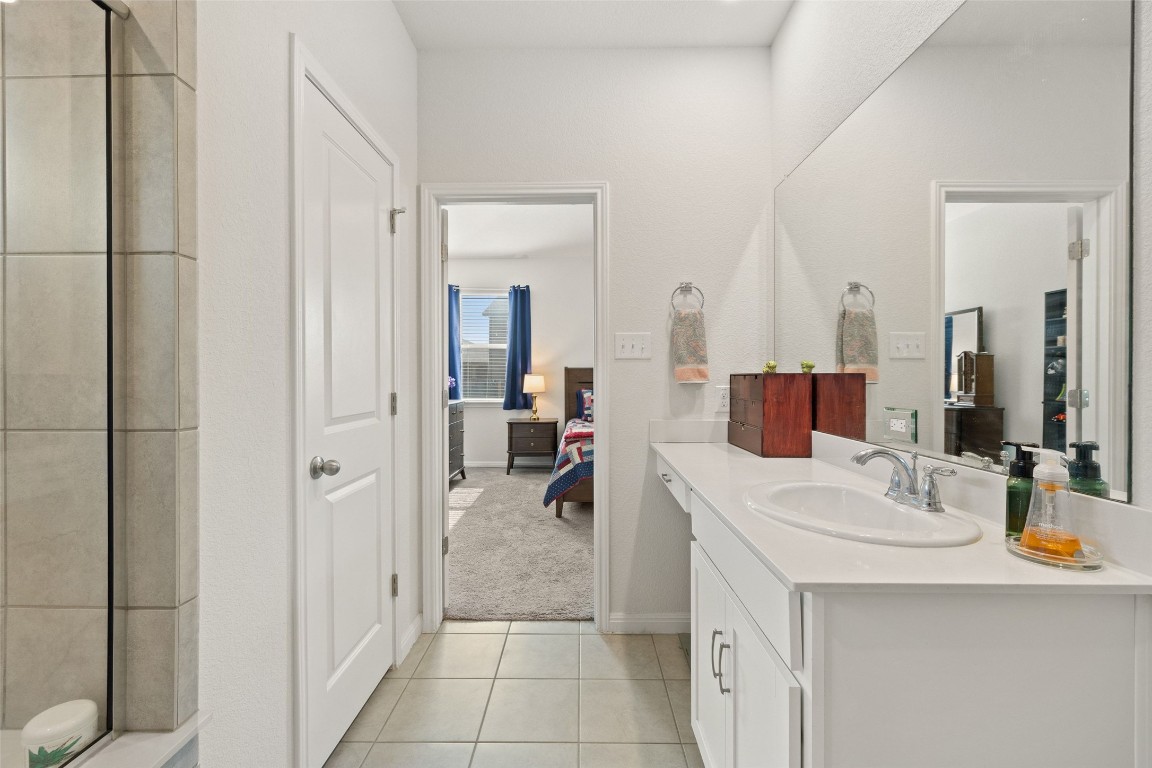 11701 Pecangate Way Manor, TX 78653 - Photo 23 of 40 a en suite bathroom with a double vanity sink and a mirror