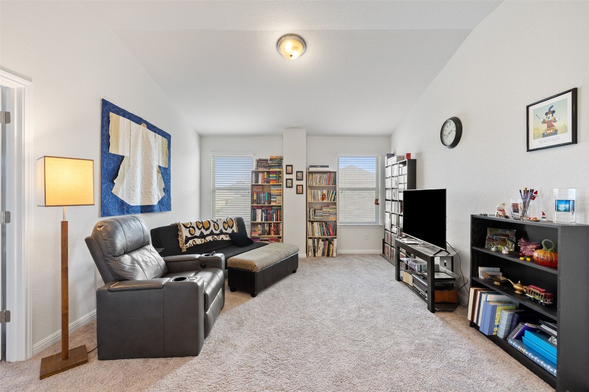 11701 Pecangate Way Manor, TX 78653 - Photo 24 of 40 a living room with furniture a flat screen tv and a bookshelf
