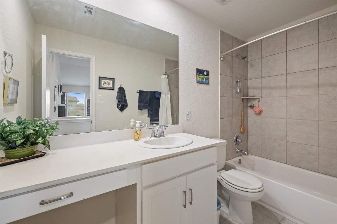 11701 Pecangate Way Manor, TX 78653 - Photo 32 of 40 a bathroom with a sink a toilet a mirror a vanity and shower