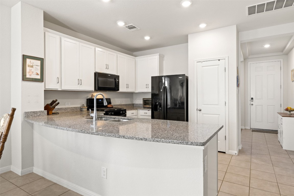 11701 Pecangate Way Manor, TX 78653 - Photo 8 of 40 a kitchen with stainless steel appliances granite countertop a refrigerator a stove a sink and a granite counter tops