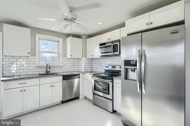 a kitchen with a refrigerator sink and cabinets