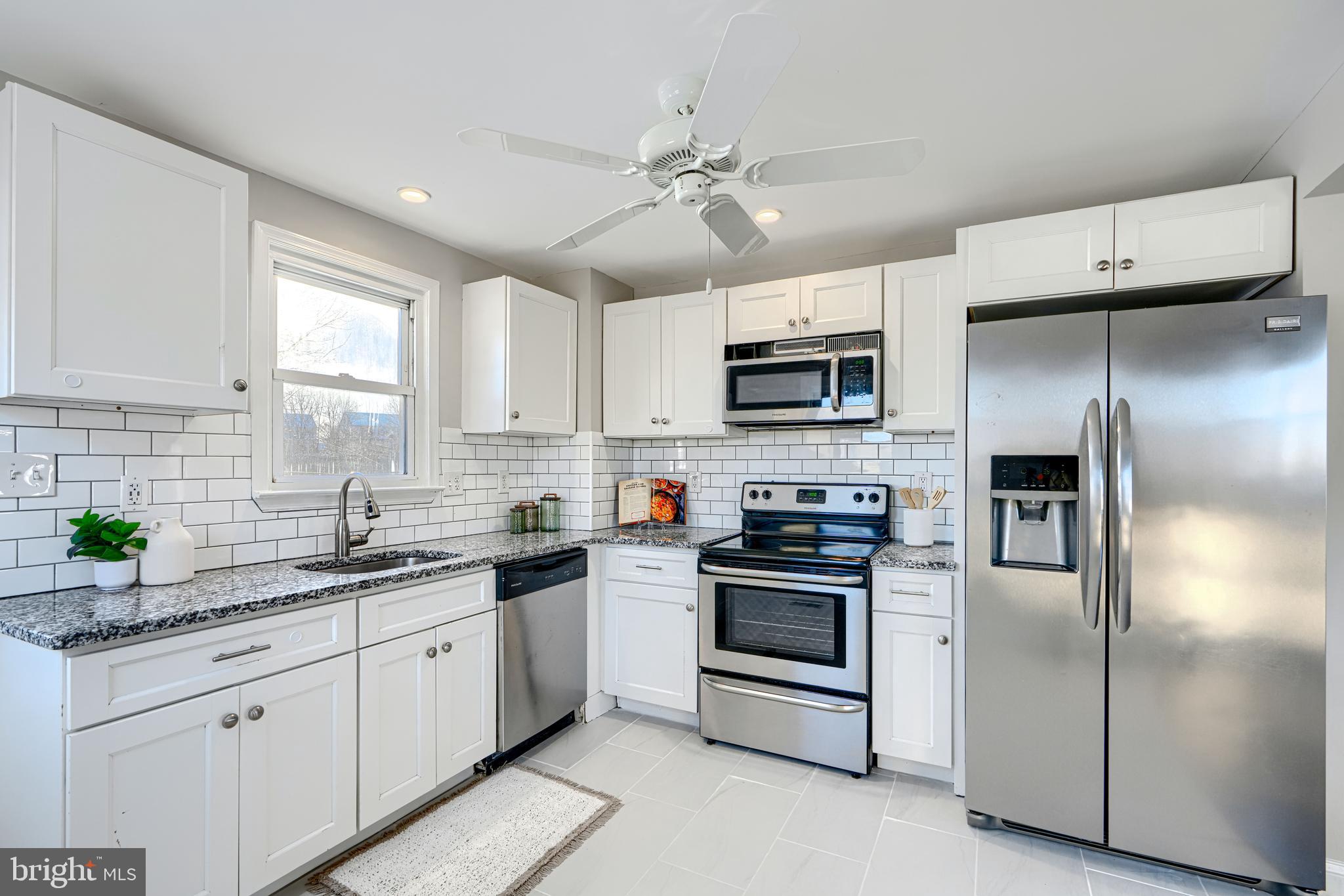 1203 Hilldale Road Baltimore, MD 21237 - Photo 15 of 55 a kitchen with cabinets stainless steel appliances a sink and a window