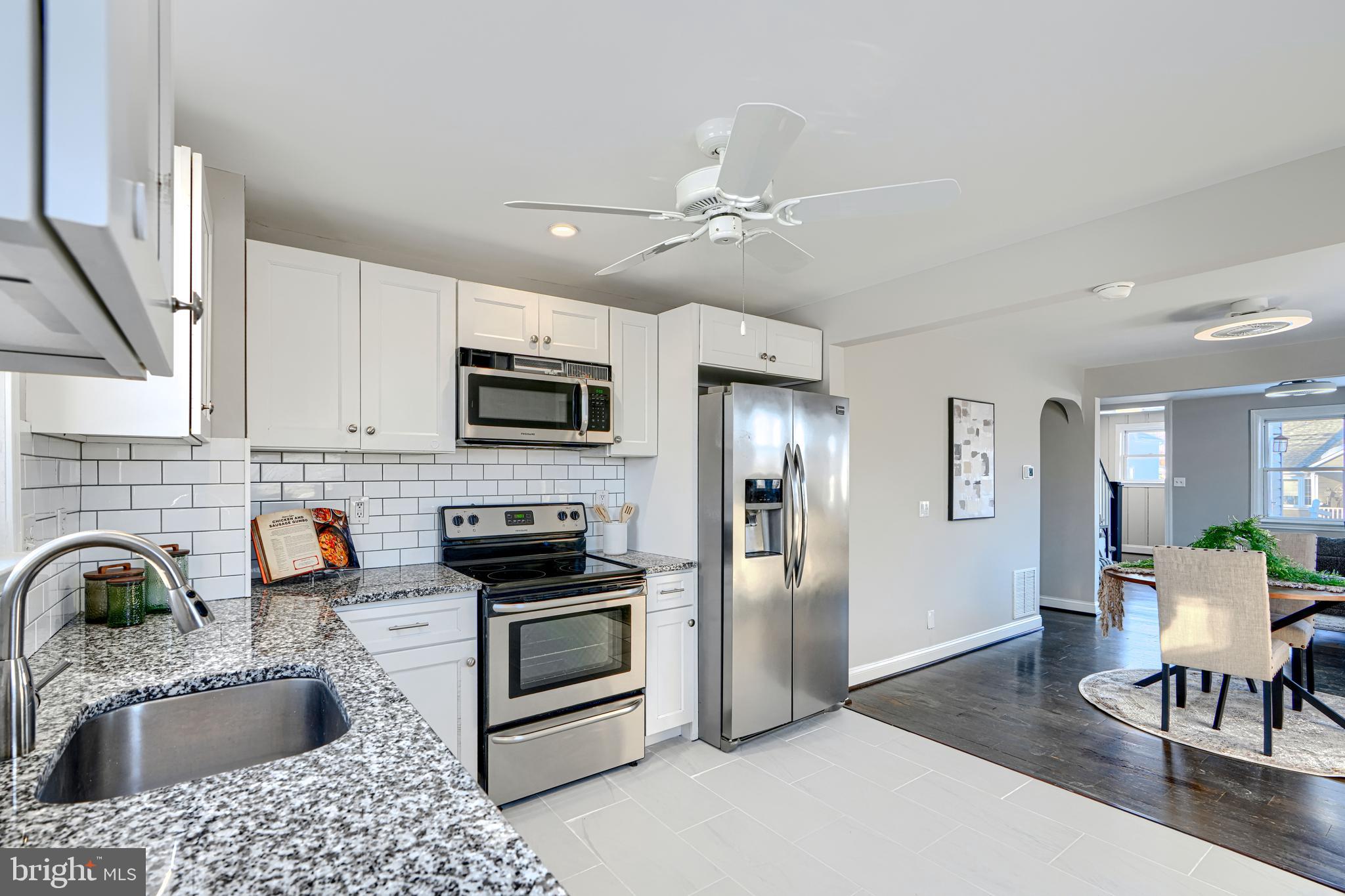 1203 Hilldale Road Baltimore, MD 21237 - Photo 16 of 55 a kitchen with stainless steel appliances granite countertop a refrigerator a stove a sink a dining table and chairs with wooden floor