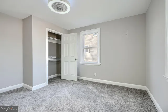 an empty room with windows and closet