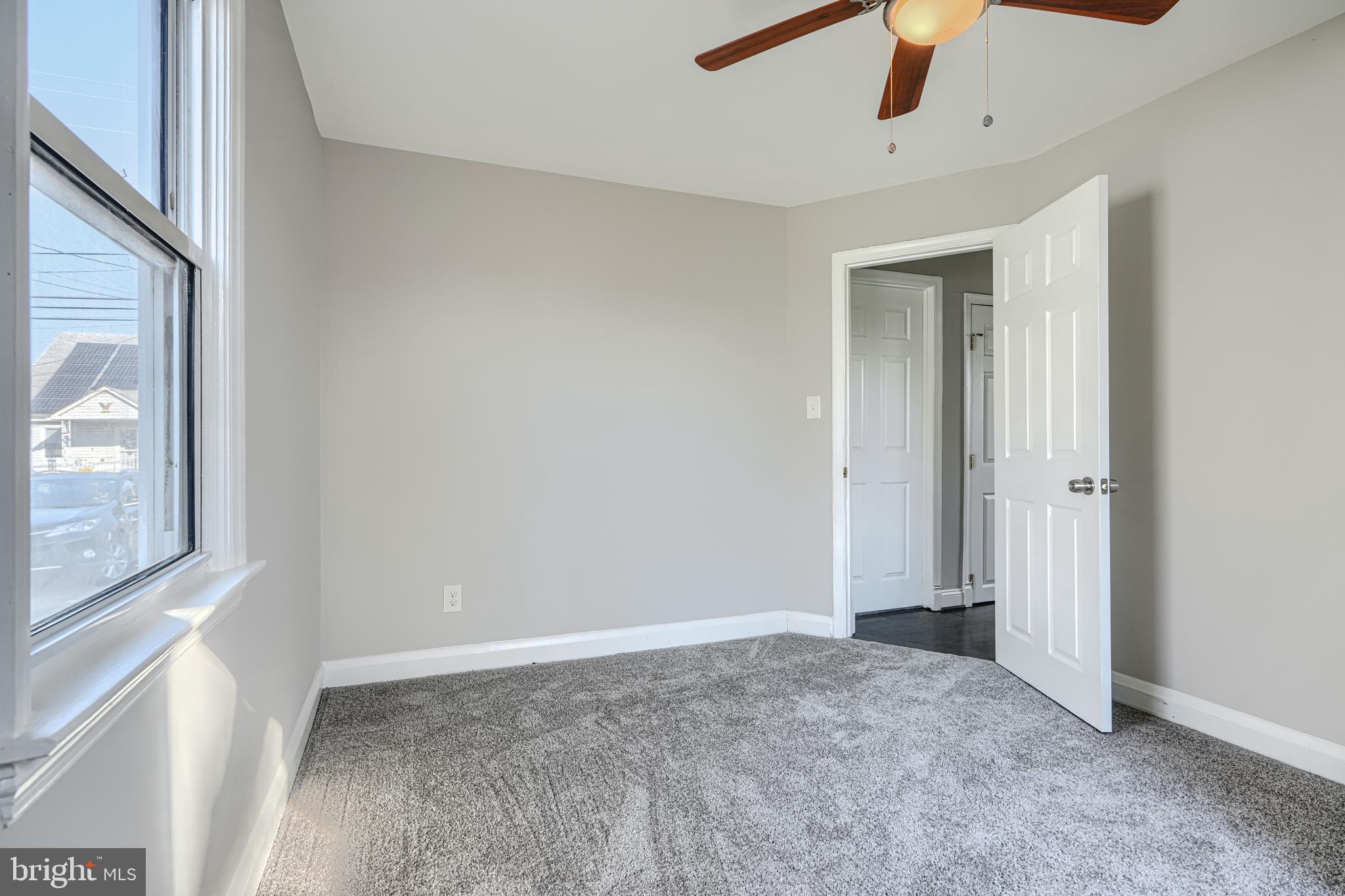 1203 Hilldale Road Baltimore, MD 21237 - Photo 28 of 55 an empty room with chandelier fan and windows