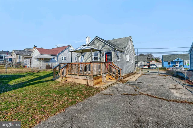a view of a white house with large windows and a small yard