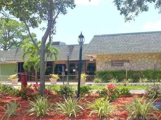 a view of a patio with table and chairs potted plants and large tree