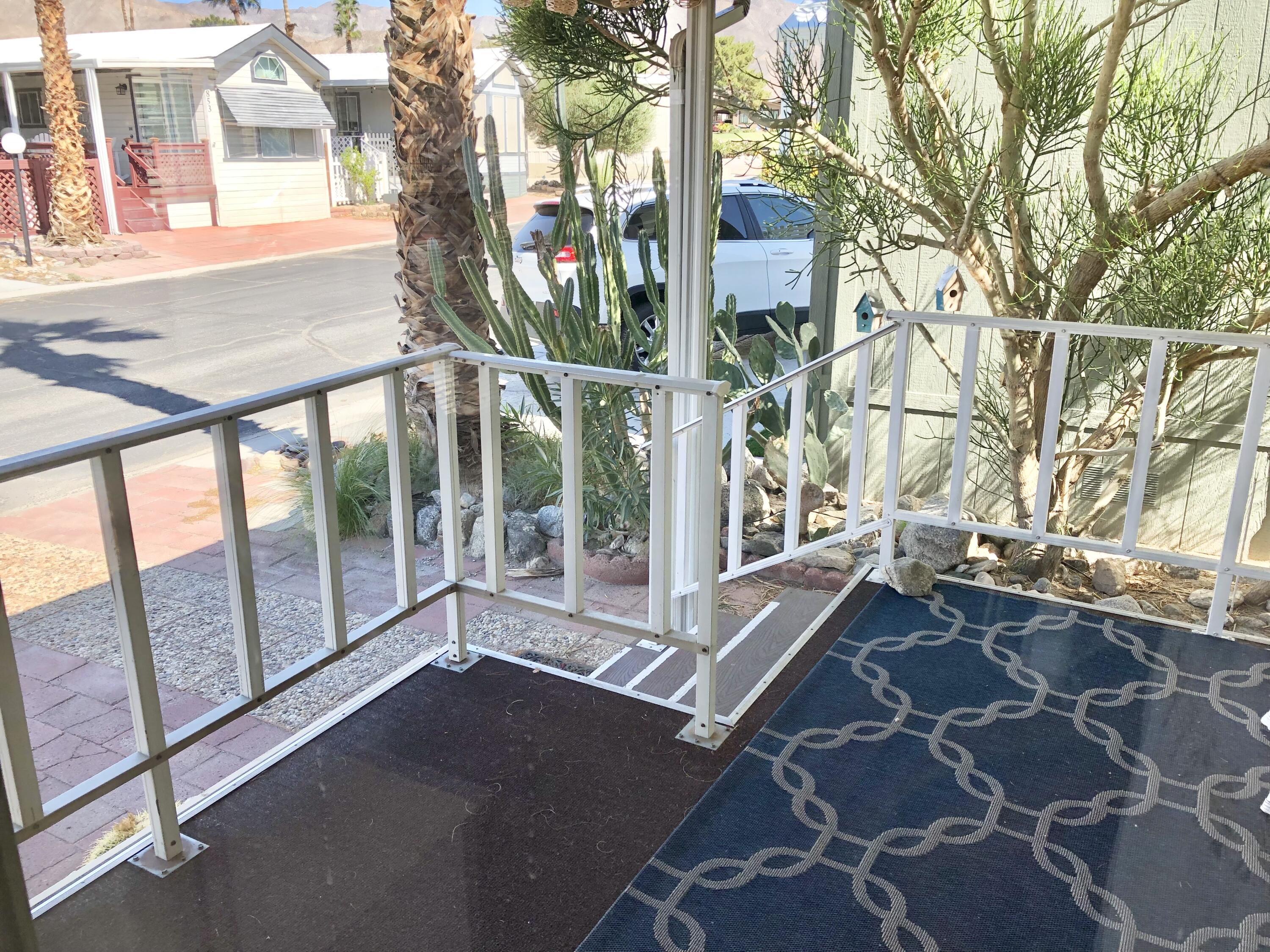 74711 Dillon Road Desert Hot Springs, CA 92241 - Photo 6 of 44 a view of a house with a large window and wooden fence