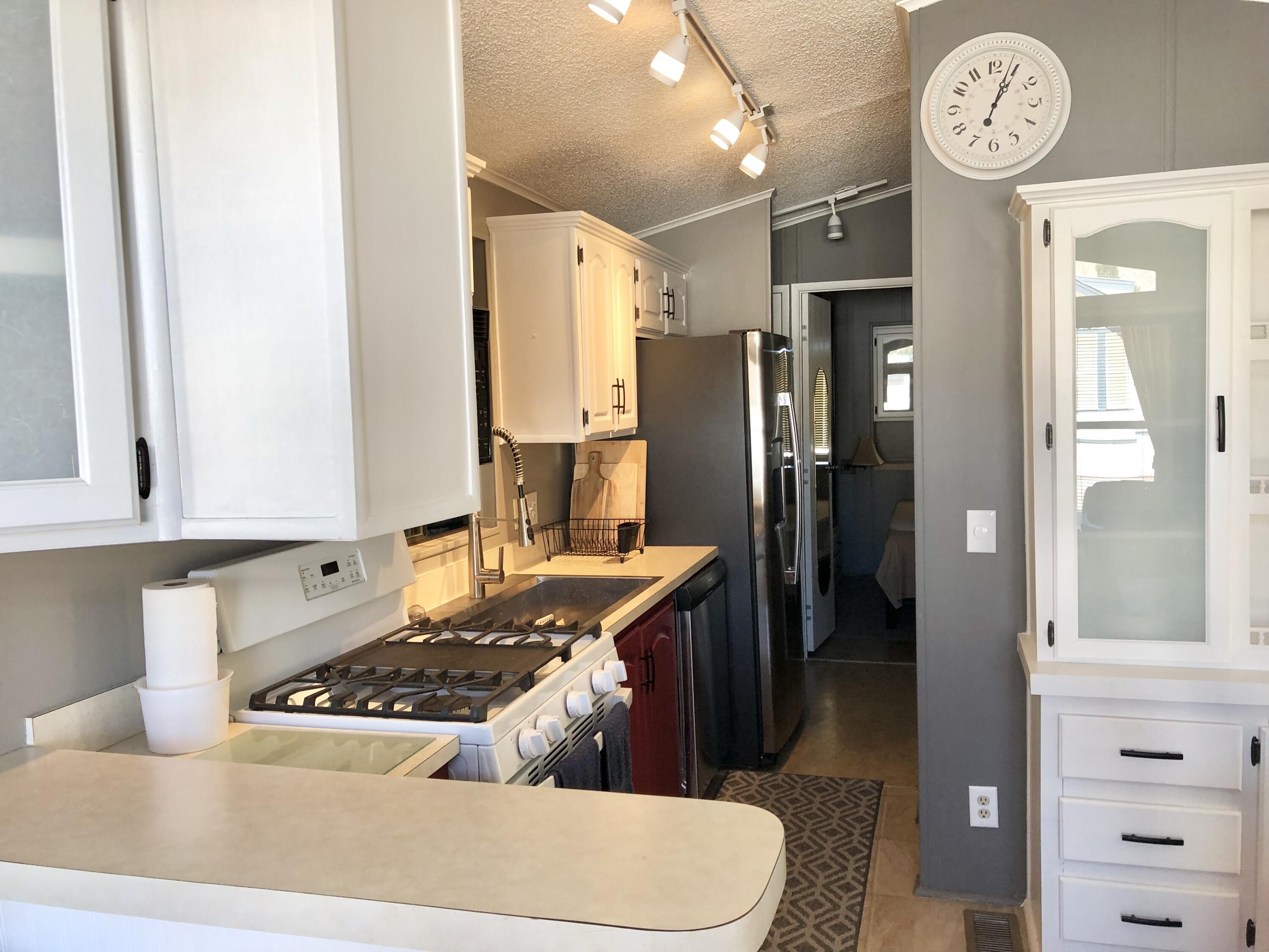 74711 Dillon Road Desert Hot Springs, CA 92241 - Photo 9 of 44 a kitchen with stainless steel appliances granite countertop a sink stove and refrigerator