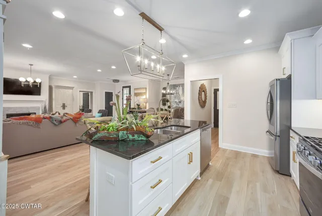 a kitchen with stainless steel appliances kitchen island granite countertop a refrigerator and a stove