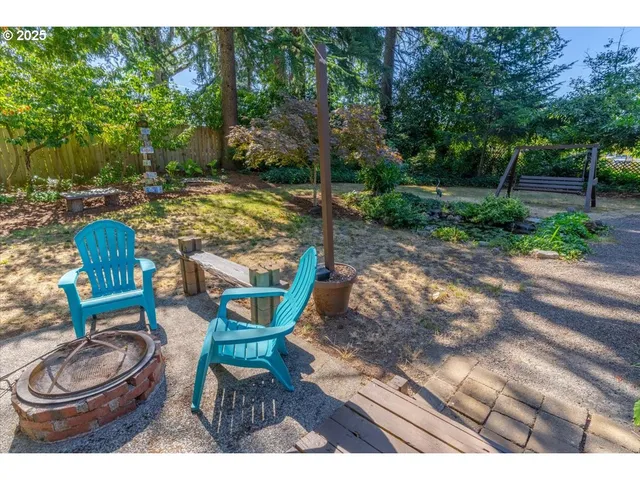 a view of a chairs and table in backyard