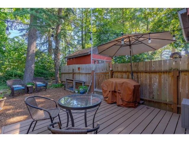 a patio with wooden floor a yard a table and chairs