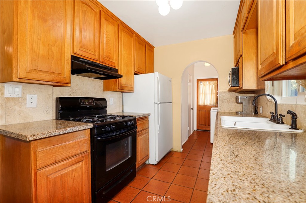 576 East Columbia Avenue Pomona, CA 91767 - Photo 13 of 27 a kitchen with stainless steel appliances granite countertop a stove a refrigerator and a sink