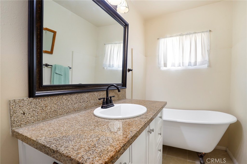 576 East Columbia Avenue Pomona, CA 91767 - Photo 17 of 27 a bathroom with a granite countertop sink and a mirror