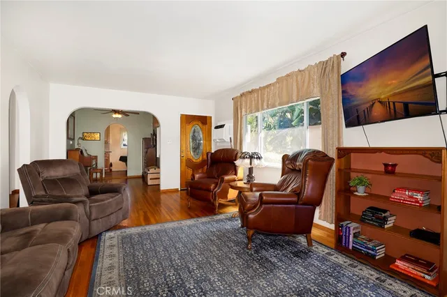 a living room with furniture a flat screen tv and a floor to ceiling window