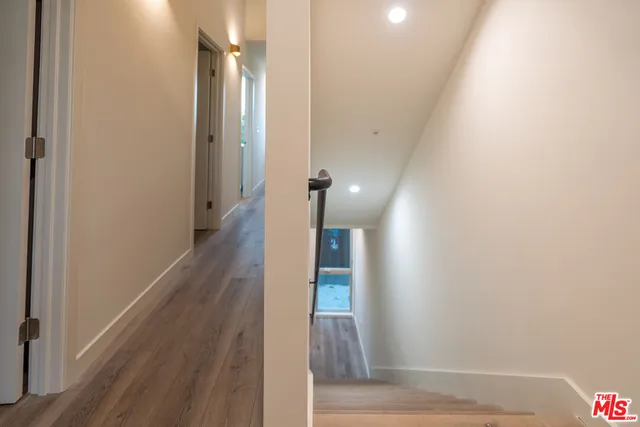 a view of a hallway with wooden floor and staircase