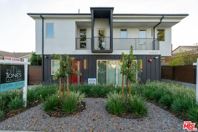 a view of a house with potted plants and a table