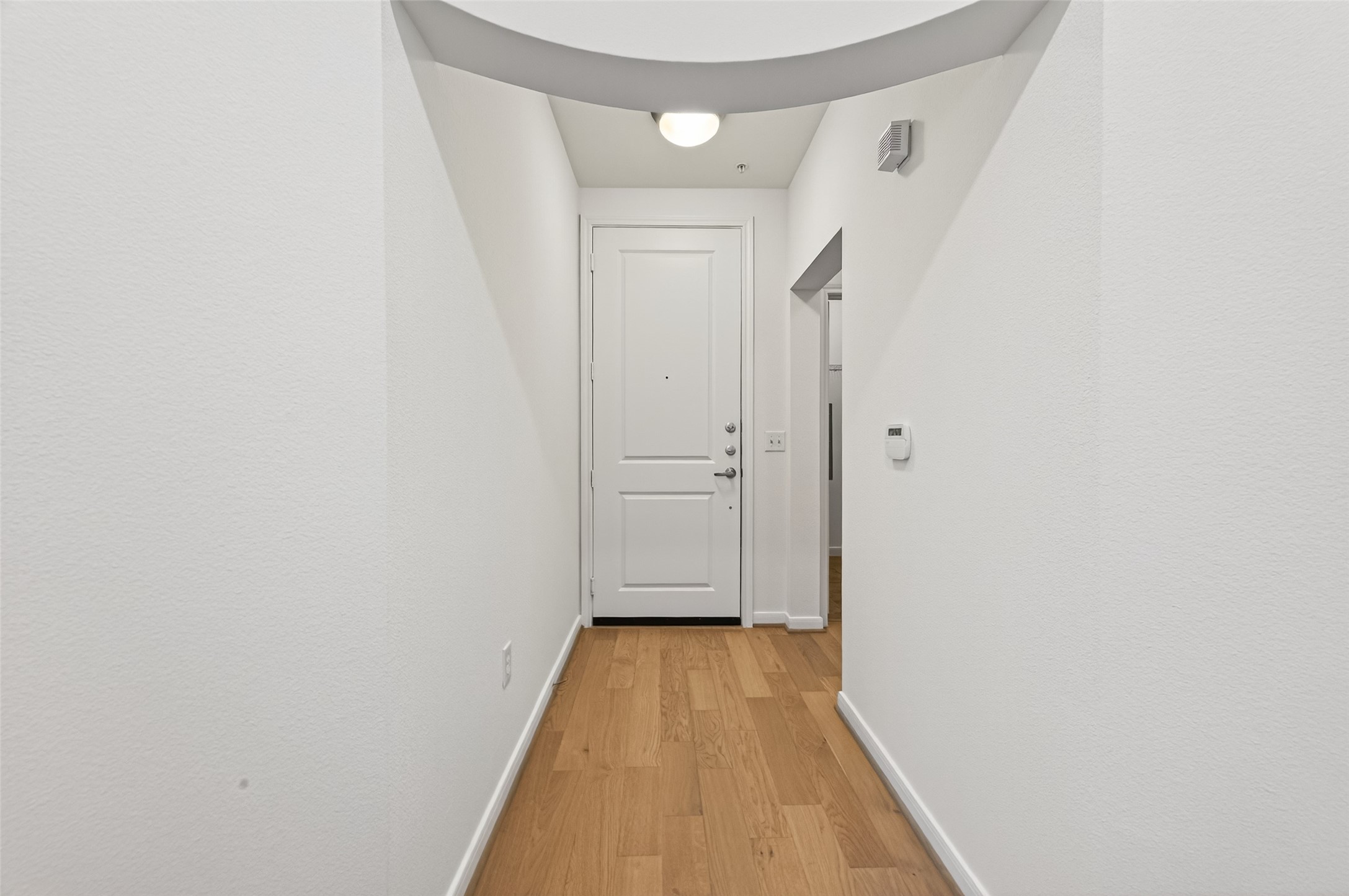 505 Jackson Hill Street, Unit 404 Houston, TX 77007 - Photo 2 of 24 a view of a hallway with wooden floor and a bathroom