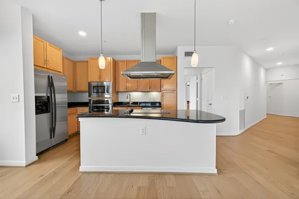a kitchen with stainless steel appliances granite countertop a sink a refrigerator and a stove