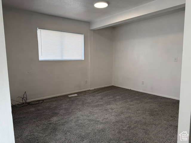420 North 200 West Logan, UT 84321 - Photo 9 of 13 Spare room featuring dark colored carpet and a textured ceiling