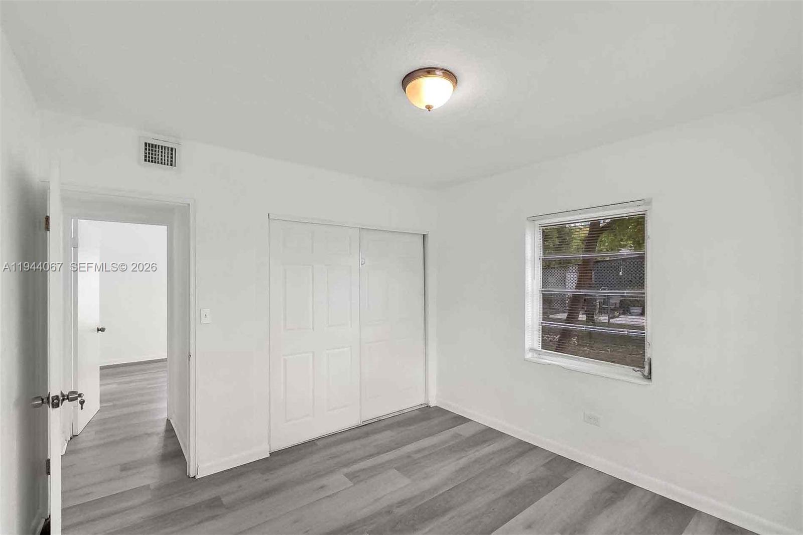 15351 Southwest 296th Street Homestead, FL 33033 - Photo 12 of 27 an empty room with wooden floor and windows