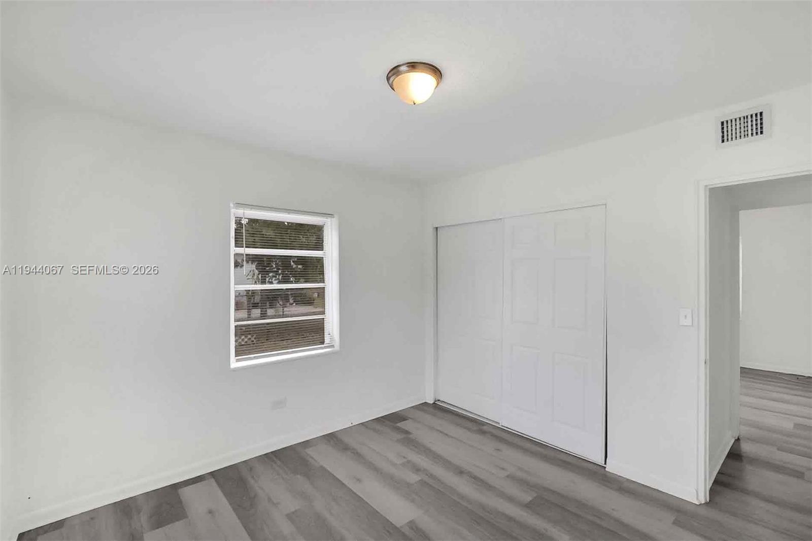 15351 Southwest 296th Street Homestead, FL 33033 - Photo 14 of 27 a view of an empty room with wooden floor and a window