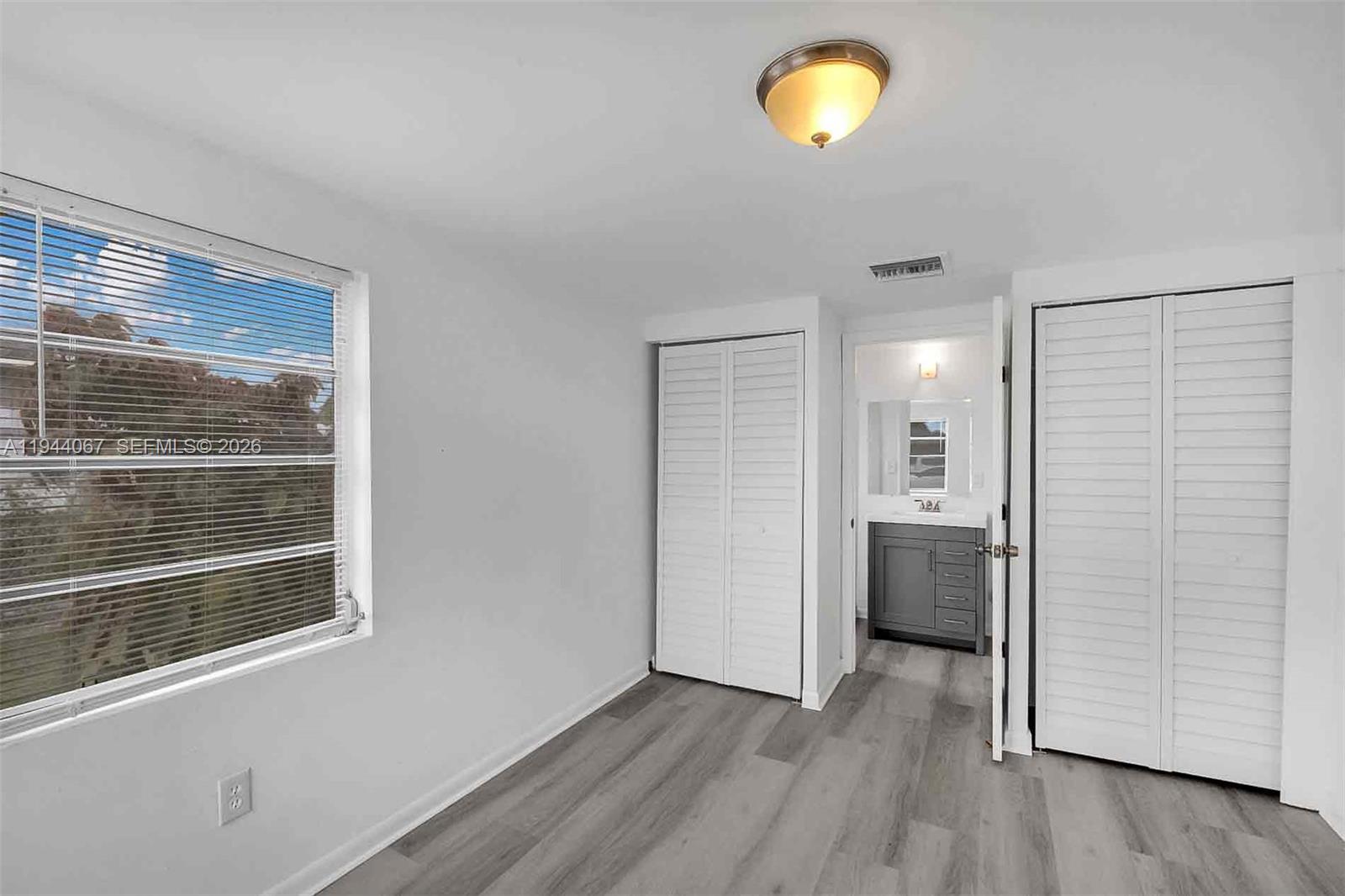 15351 Southwest 296th Street Homestead, FL 33033 - Photo 16 of 27 a view of an empty room with a window and wooden floor