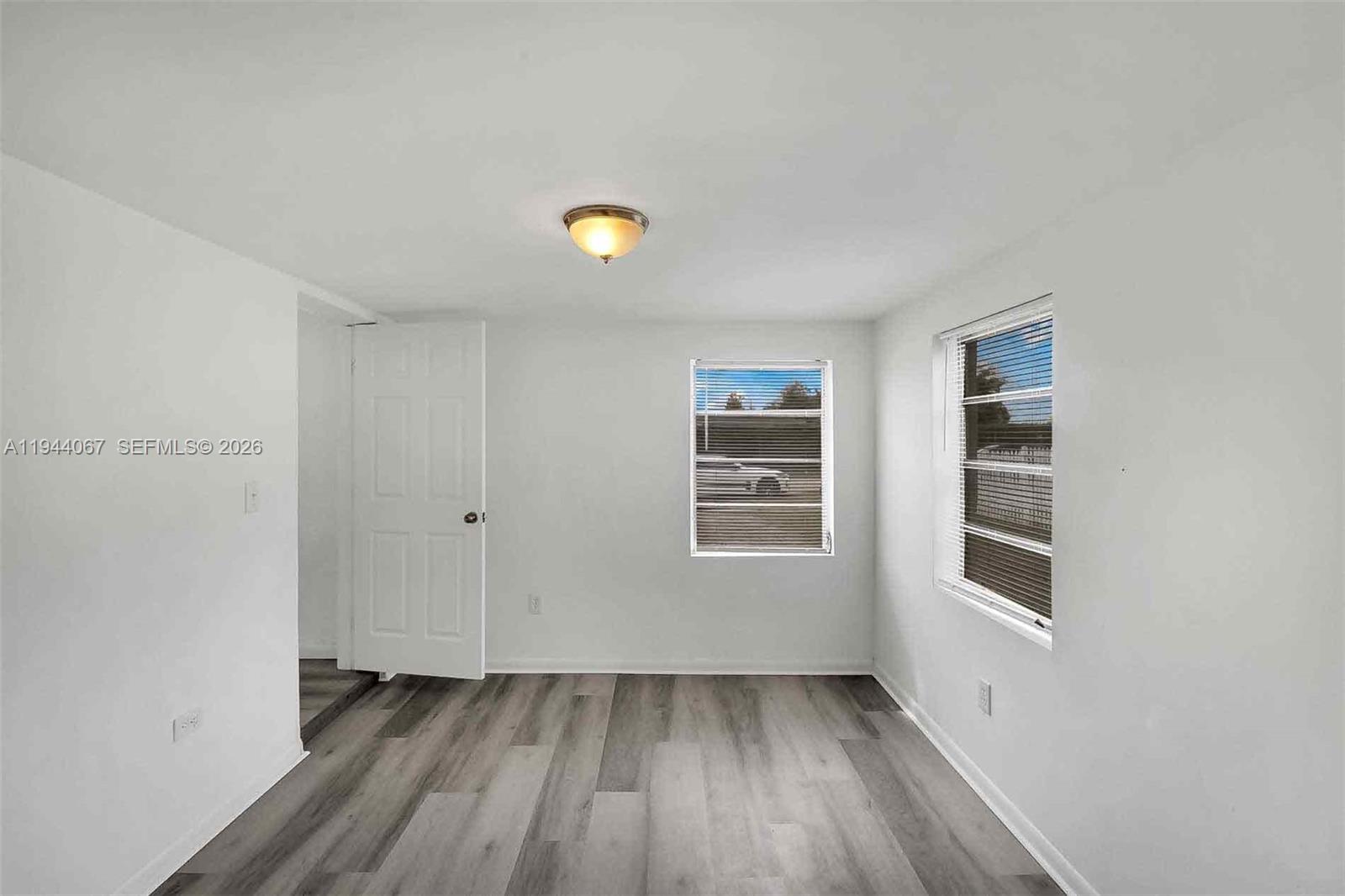 15351 Southwest 296th Street Homestead, FL 33033 - Photo 18 of 27 a view of an empty room with a window and wooden floor