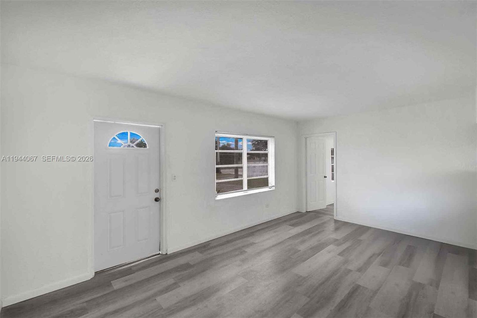 15351 Southwest 296th Street Homestead, FL 33033 - Photo 6 of 27 a view of an empty room with wooden floor and a window