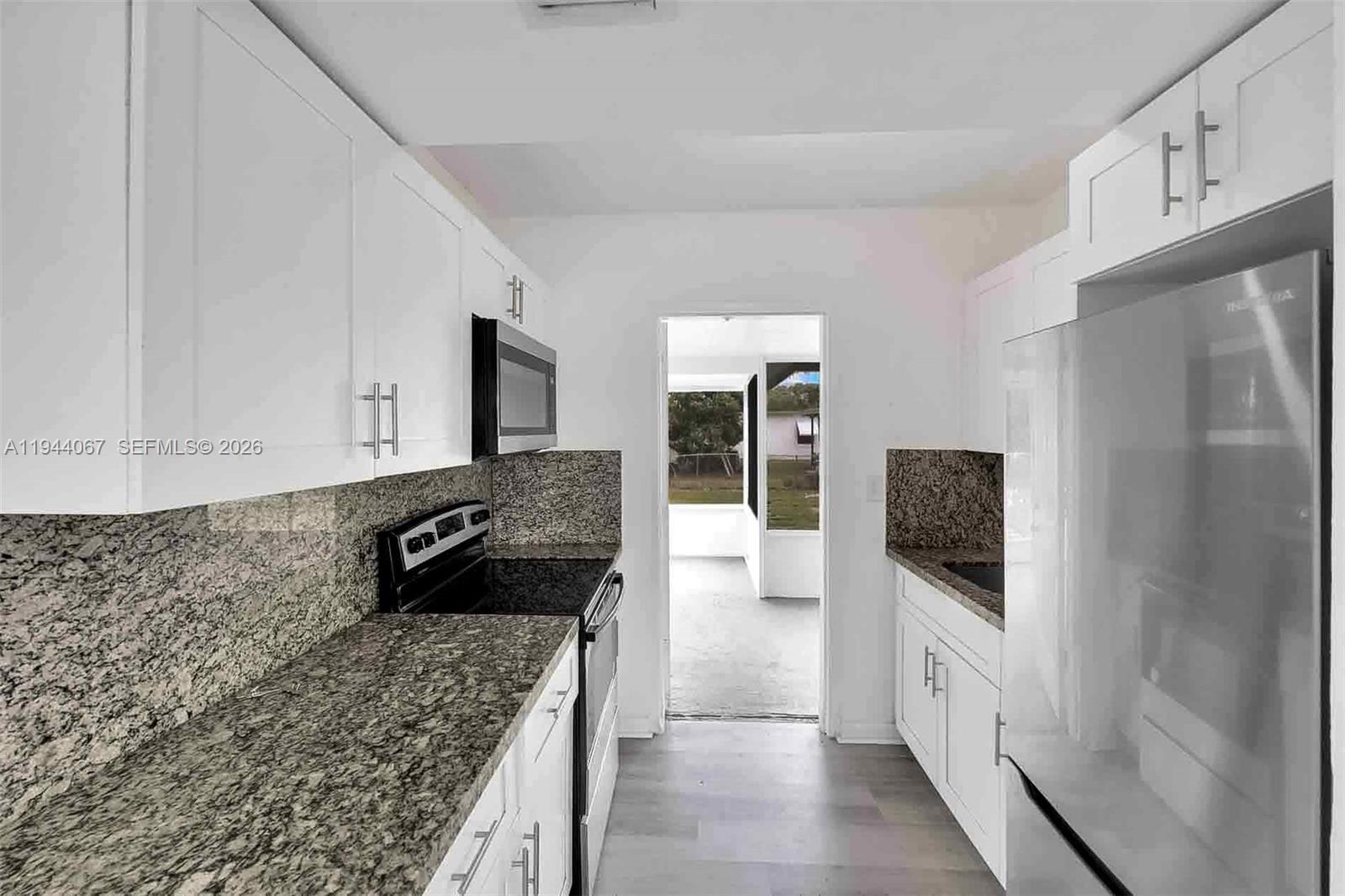 15351 Southwest 296th Street Homestead, FL 33033 - Photo 9 of 27 a kitchen with granite countertop a refrigerator stove and sink