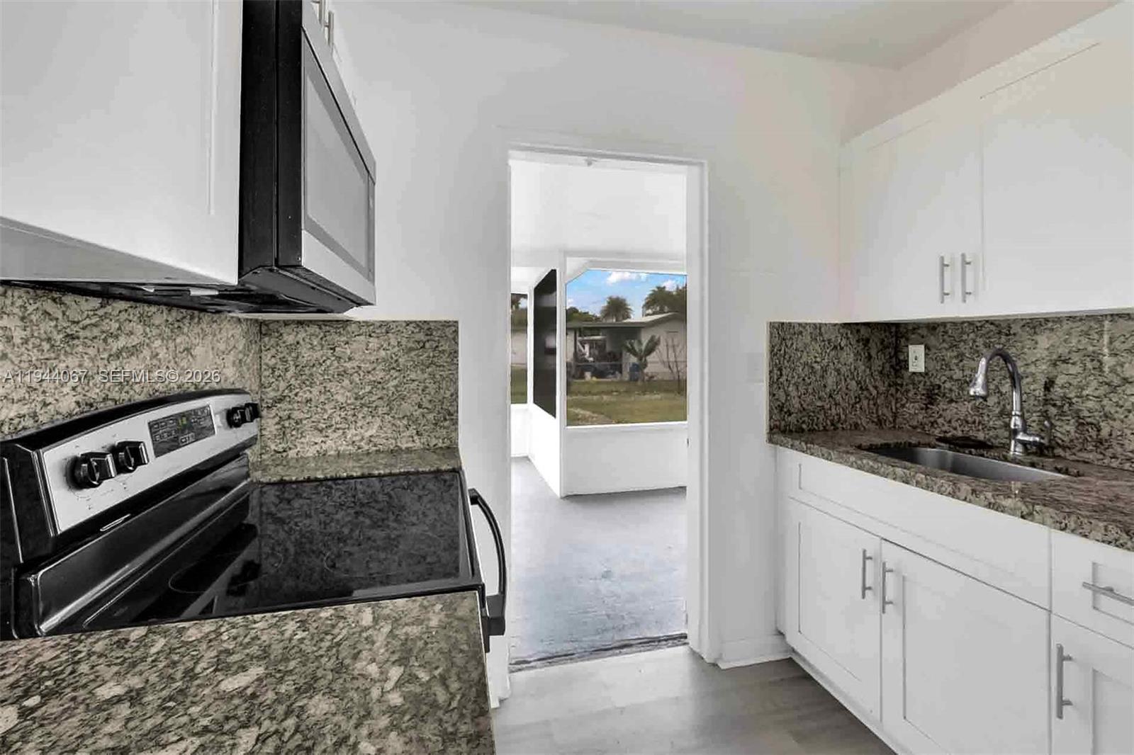 15351 Southwest 296th Street Homestead, FL 33033 - Photo 10 of 27 a kitchen with granite countertop a sink and a stove top oven
