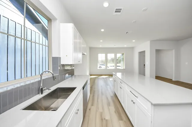a large kitchen with granite countertop a large window and a sink