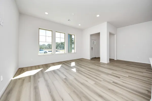 a large white kitchen with wooden floor and a sink