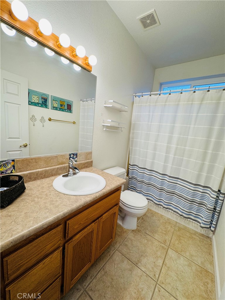 5770 Colorado River Road Blythe, CA 92225 - Photo 13 of 34 a bathroom with a granite countertop sink mirror vanity and toilet