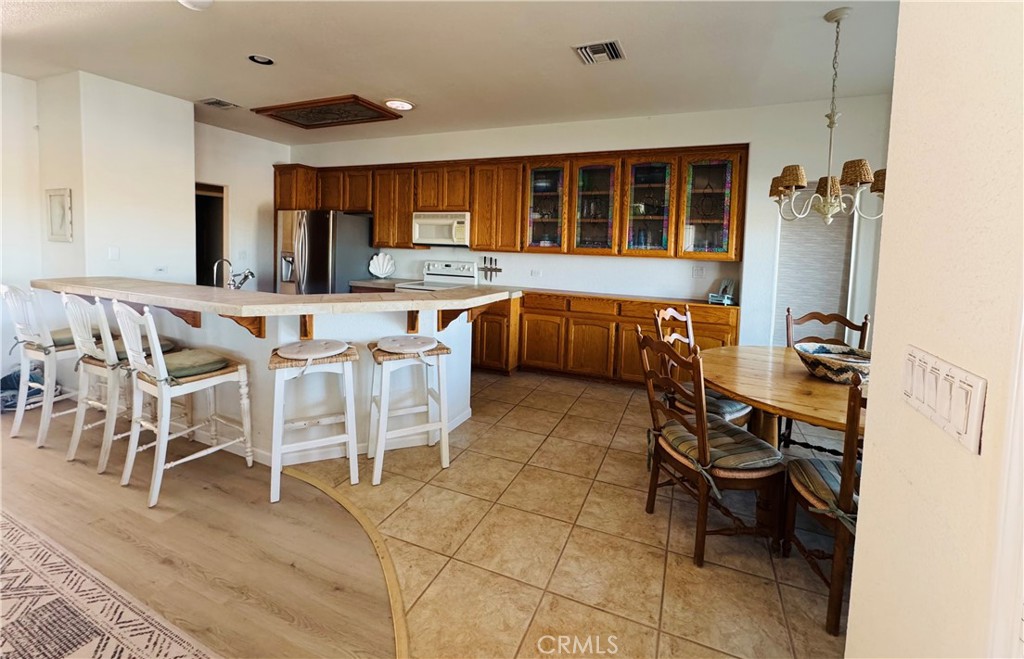 5770 Colorado River Road Blythe, CA 92225 - Photo 7 of 34 a kitchen with a dining table chairs and white cabinets