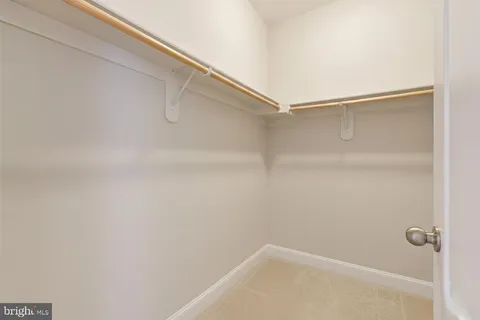 a view of a patio with table and chairs under an umbrella with large trees