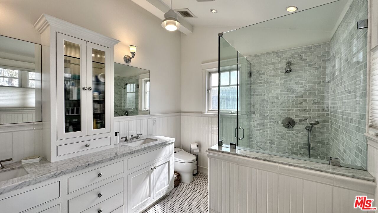 910 Marco Place Venice, CA 90291 - Photo 22 of 43 a bathroom with a granite countertop sink a toilet a mirror and shower