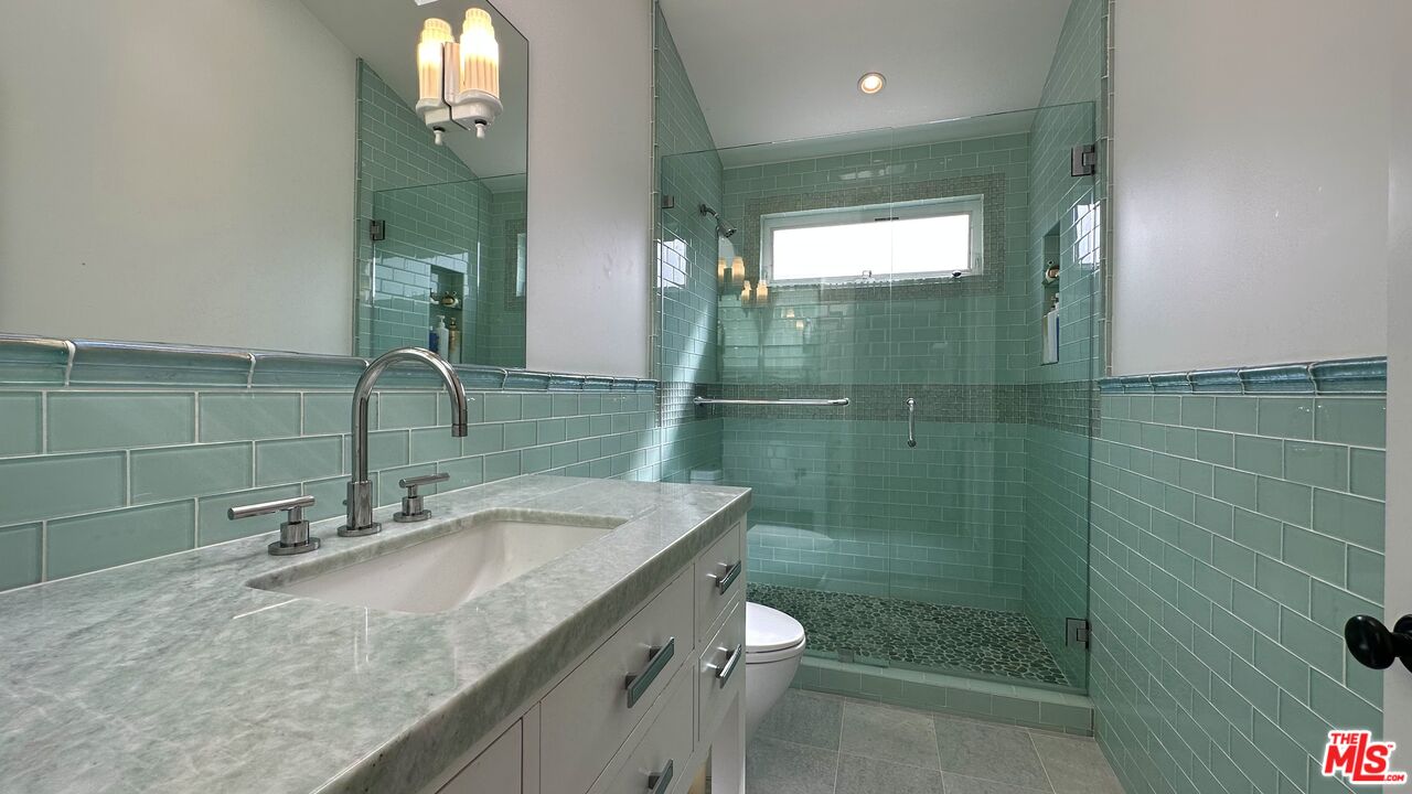 910 Marco Place Venice, CA 90291 - Photo 29 of 43 a bathroom with a granite countertop sink a toilet and shower