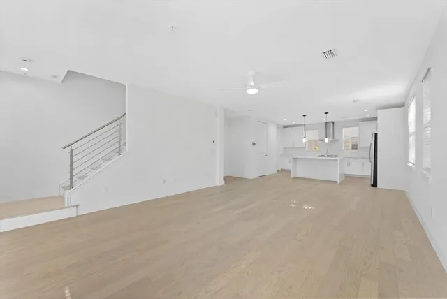 a view of a kitchen with refrigerator and white cabinets
