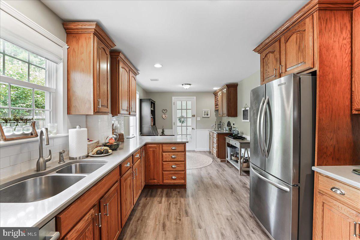 400 Southcroft Road Springfield, PA 19064 - Photo 14 of 44 a kitchen with stainless steel appliances granite countertop a refrigerator a sink dishwasher a stove and a refrigerator with wooden floor
