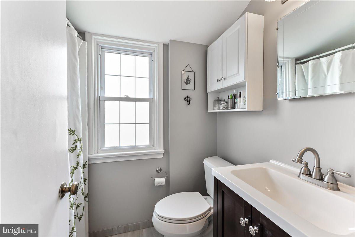 400 Southcroft Road Springfield, PA 19064 - Photo 27 of 44 a bathroom with a toilet a sink a mirror and a window