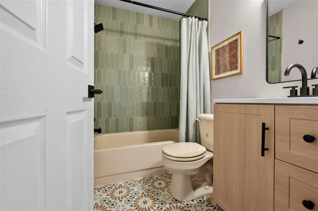 a view of a hallway to a livingroom with wooden floor and furniture