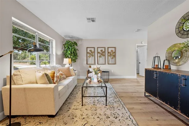 a living room with furniture and wooden floor