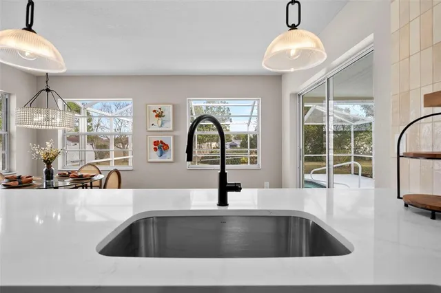 a dining room with furniture a chandelier and wooden floor