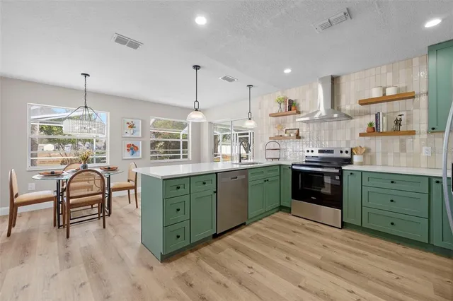 a kitchen with kitchen island granite countertop a sink cabinets and wooden floor