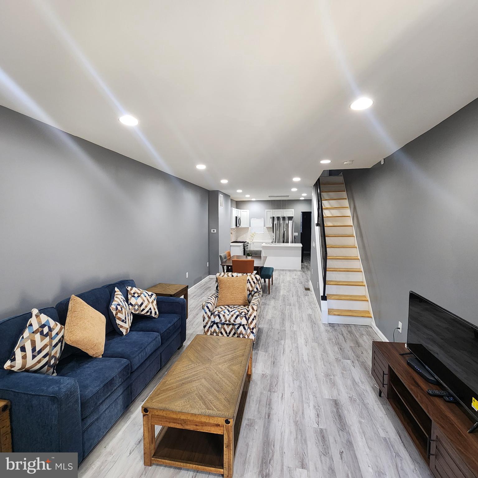 a living room with furniture and a wooden floor