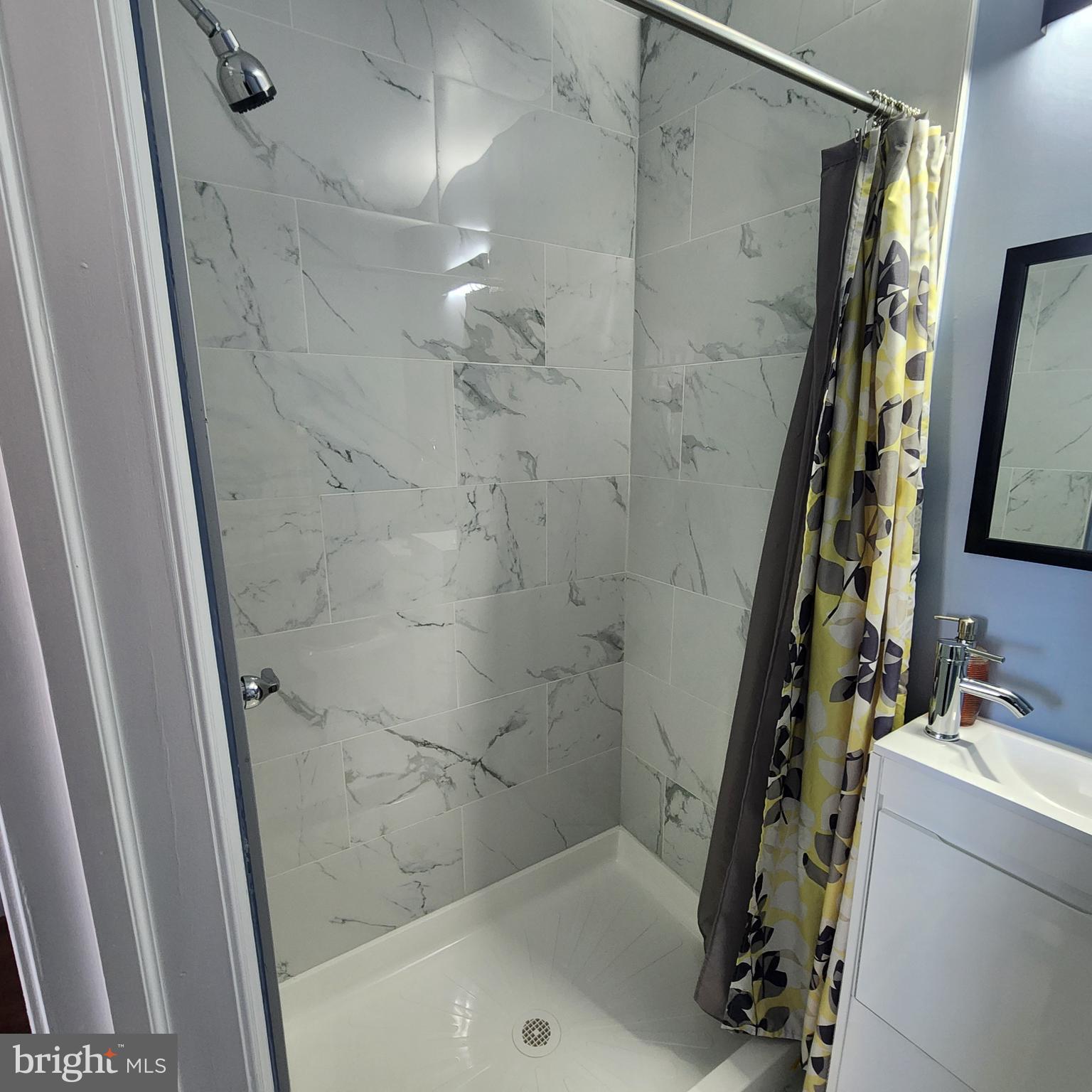 1926 East 28th Street Baltimore, MD 21218 - Photo 15 of 19 a bathroom with a sink a mirror and shower