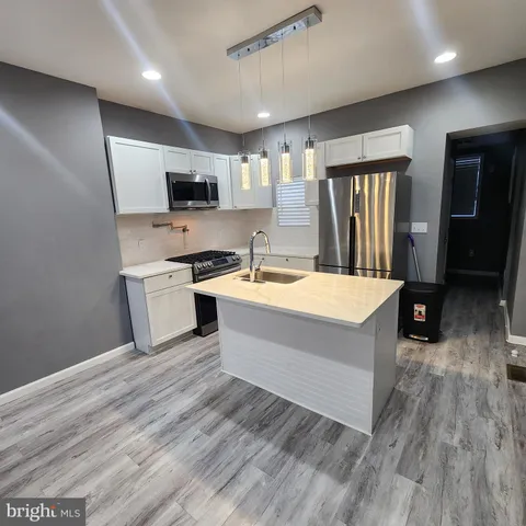 a kitchen with stainless steel appliances a sink a stove a microwave and cabinets