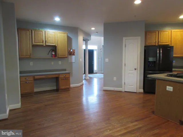 a view of an empty room with wooden floor and a fireplace